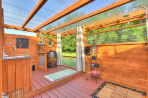 Enjoy the outside bathroom w/curtain for privacy facing a wooded area.