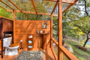 An Outside Bathroom and shower with curtains as well for privacy