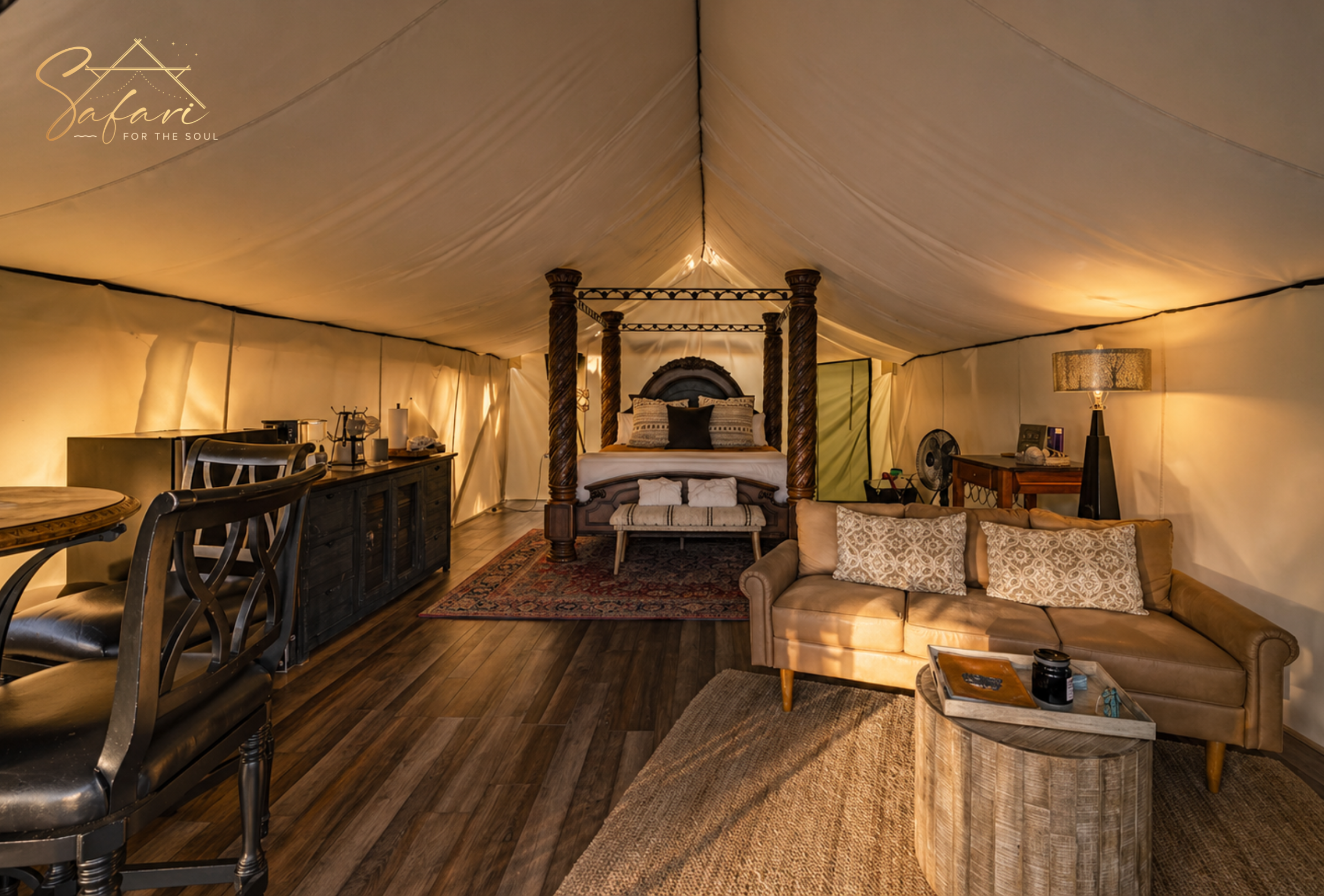 Luxury interior of Moonlight Magic Yurt in Marble Falls, TX featuring four-poster king bed, cozy sofa, kitchenette, and spacious glamping suite.
