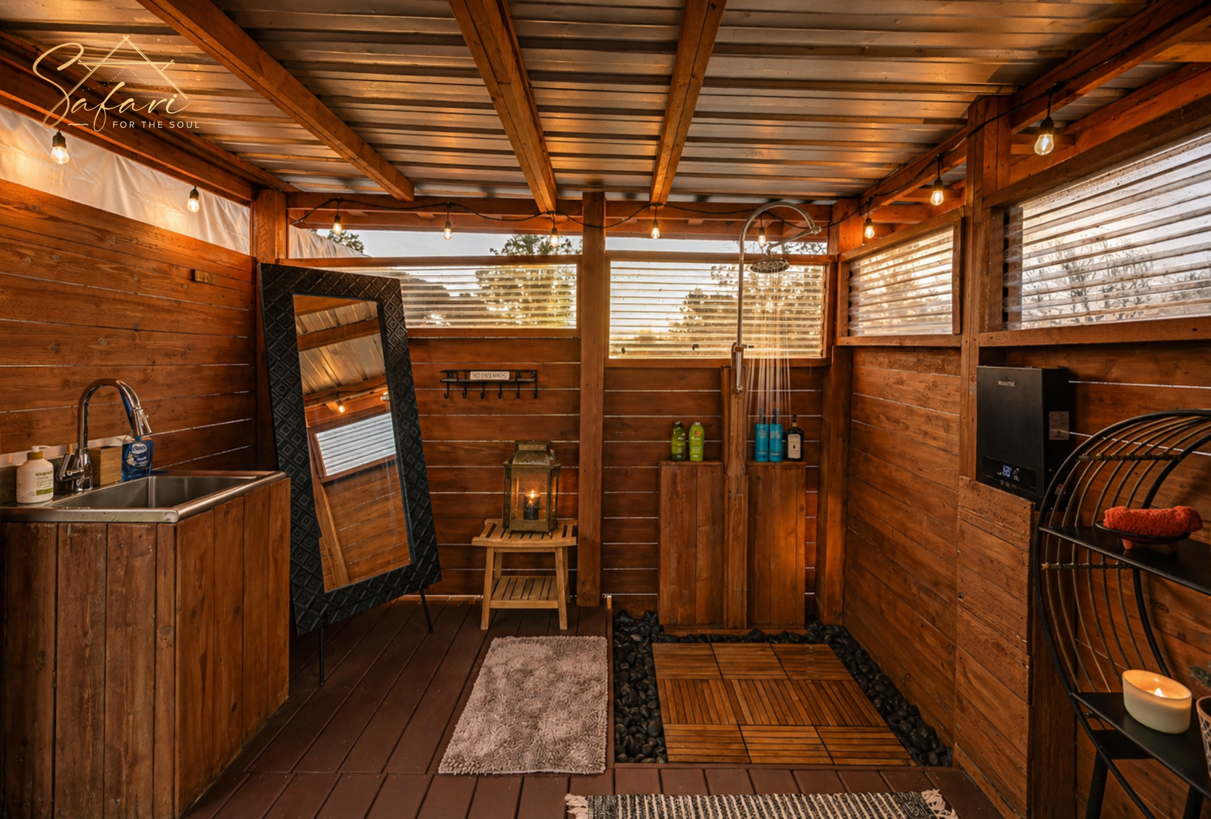 Luxury outdoor bathroom at Starry Nights Yurt in Marble Falls TX featuring rainfall shower, sink vanity, full-length mirror, wood walls, and warm lighting.