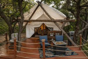 Front view of Tentation Yurt in Spicewood, TX with spacious private deck, outdoor seating, fire table, BBQ grill, and wooded Hill Country surroundings.