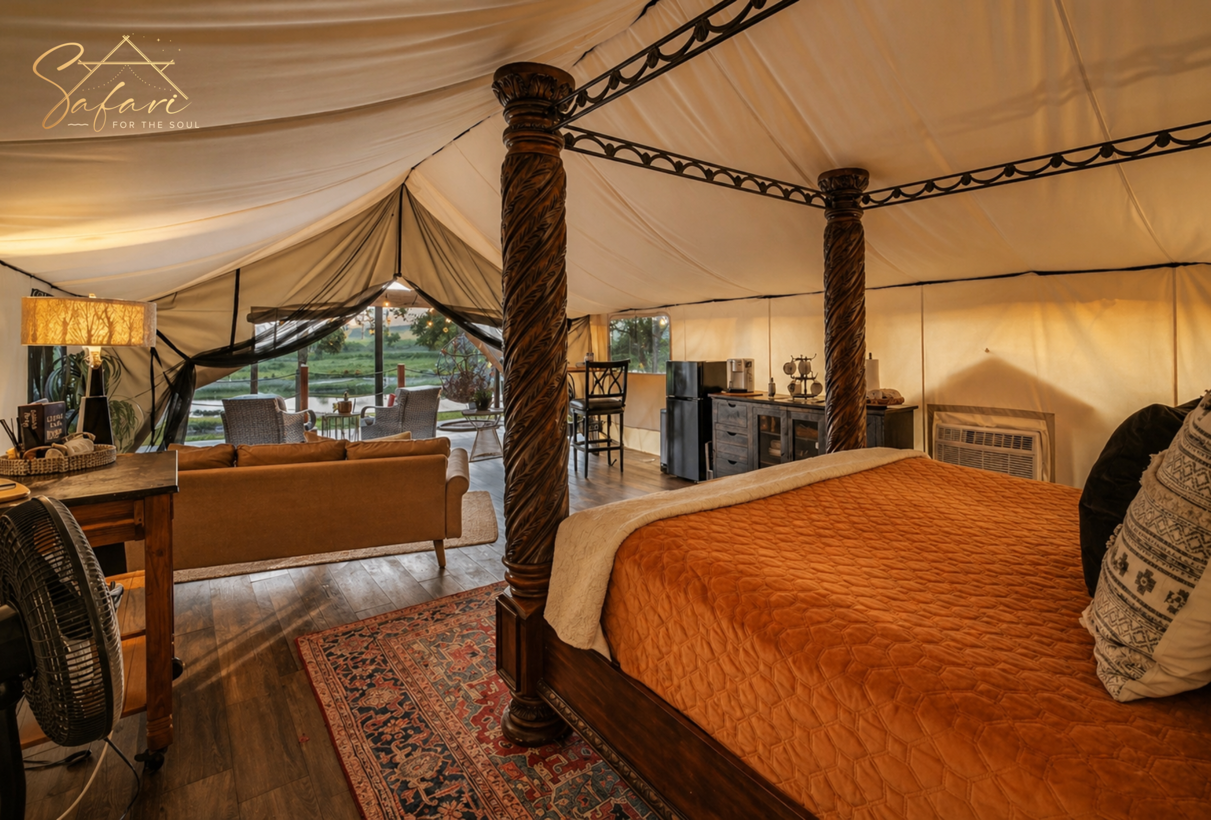 Luxury interior of Moonlight Magic Yurt in Marble Falls TX featuring a four-poster king bed, lounge seating, kitchenette, and scenic deck views.