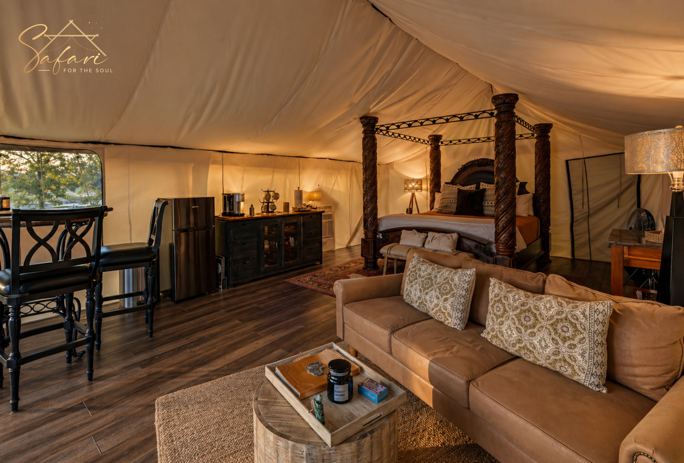 Luxury interior of Moonlight Magic Yurt in Marble Falls, TX featuring a four-poster king bed, cozy sofa, mini kitchenette, and elegant glamping décor.