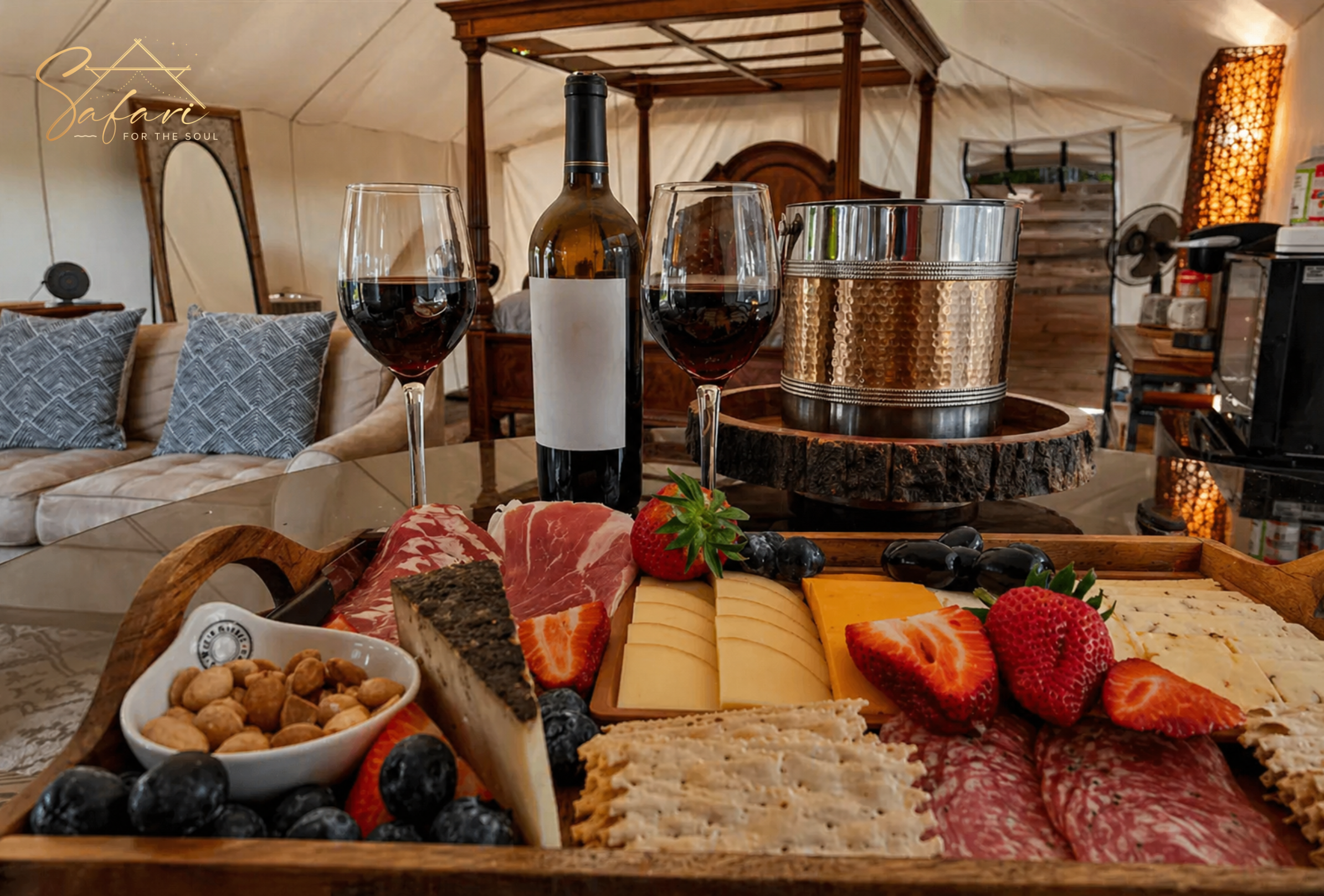 Close up of charcuterie board with cheese, fruits, crackers and wine glasses