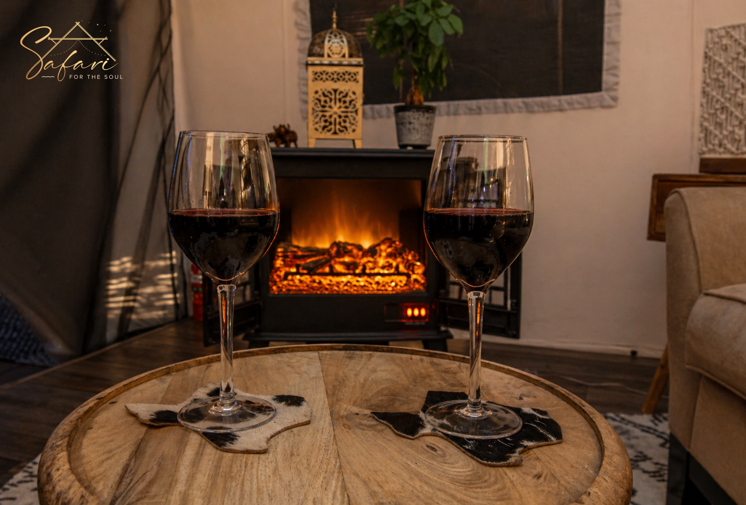 Wine glasses placed near indoor fireplace creating cozy romantic atmosphere