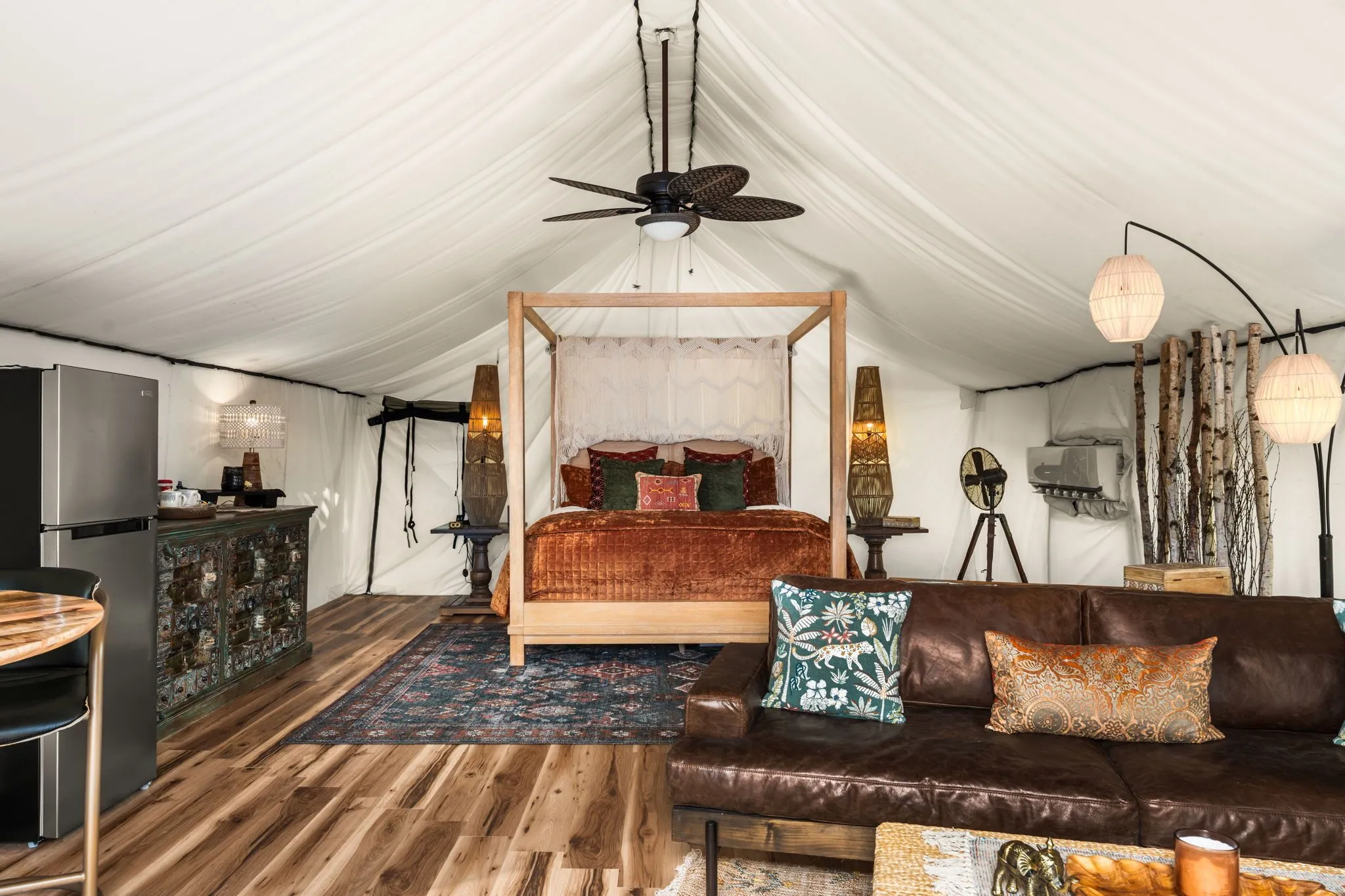 Luxury glamping yurt interior with king canopy bed and stylish lounge area in Marble Falls Texas
