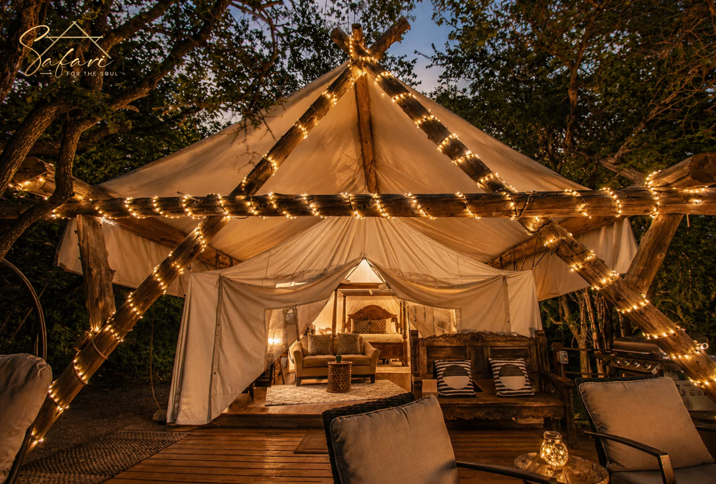 Glamping tent illuminated with warm string lights at night in wooded setting