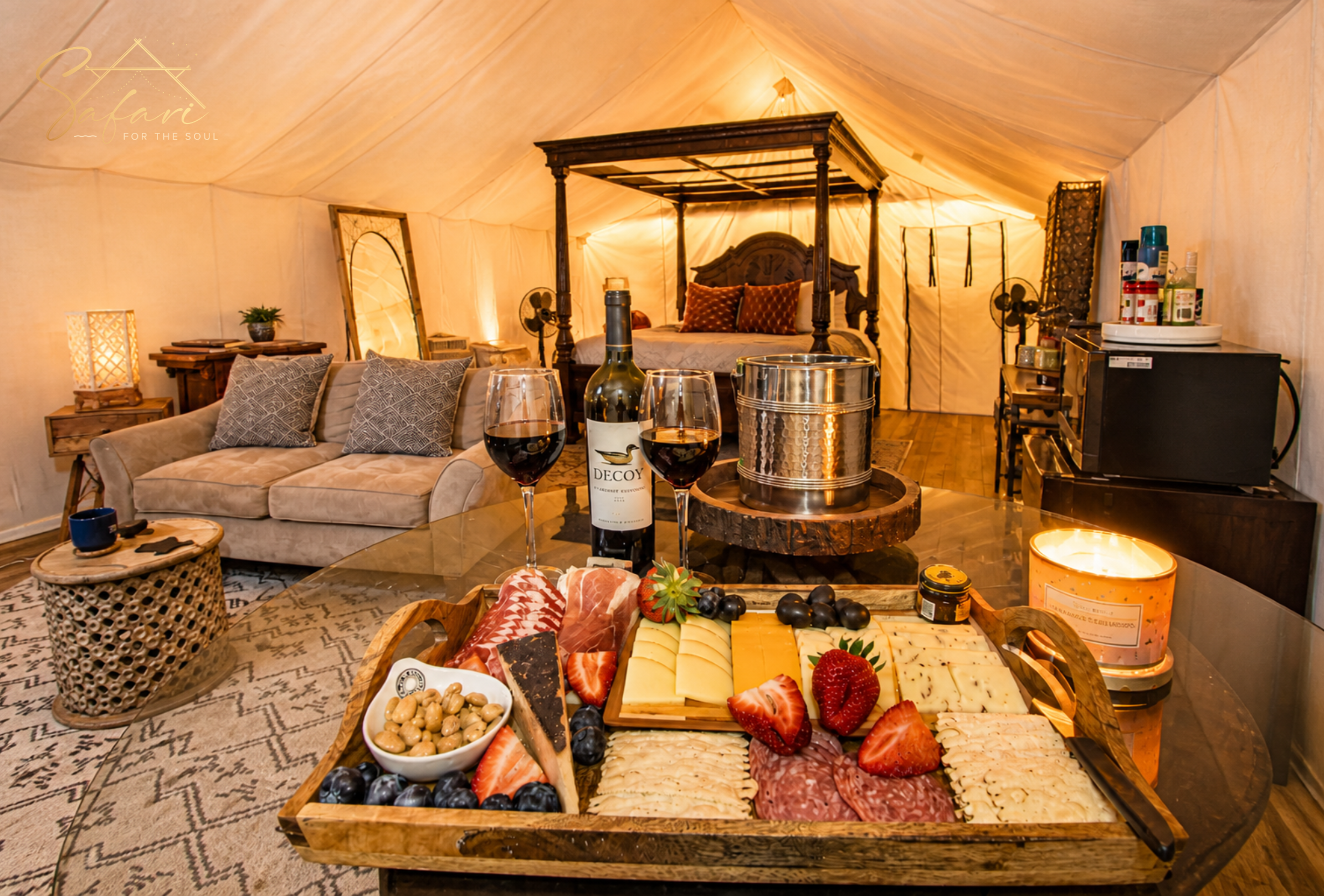 Charcuterie board with wine inside luxury glamping tent interior with cozy seating