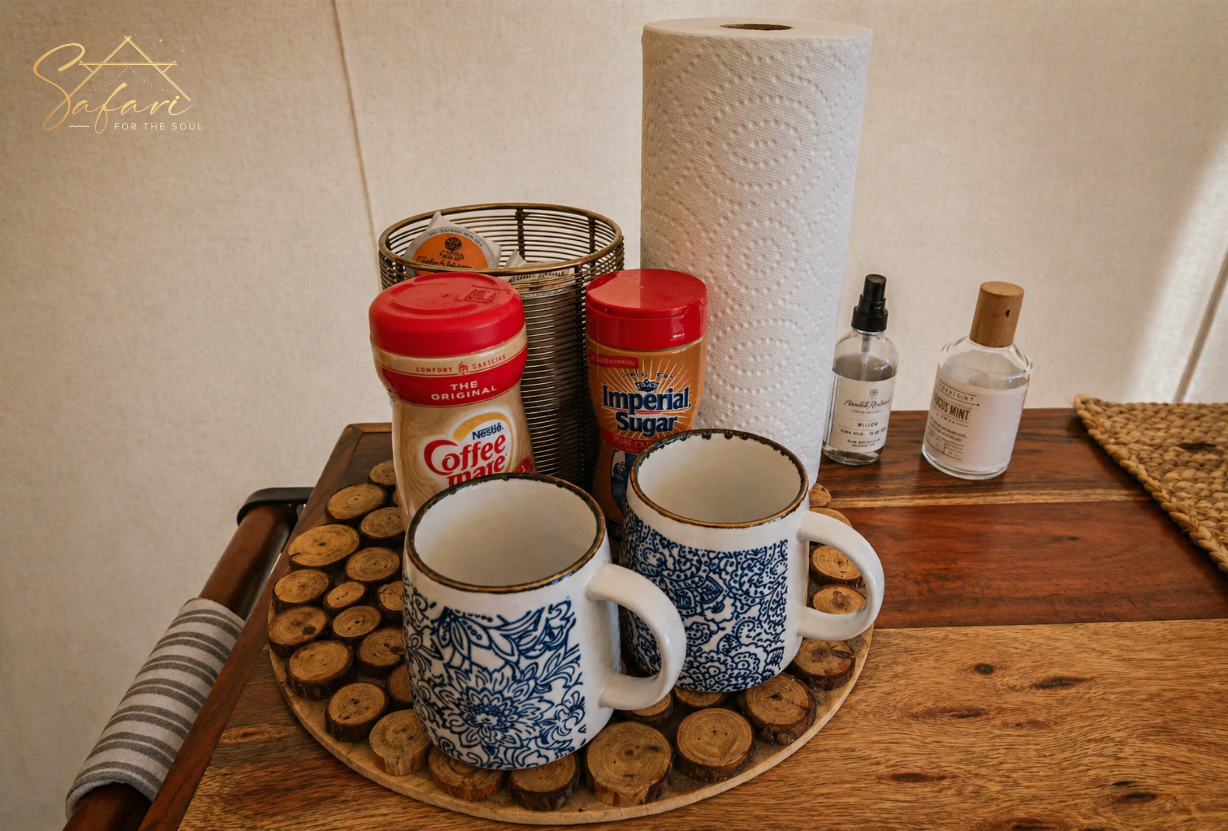 Coffee setup with mugs, sugar, and cream on rustic wooden table inside yurt