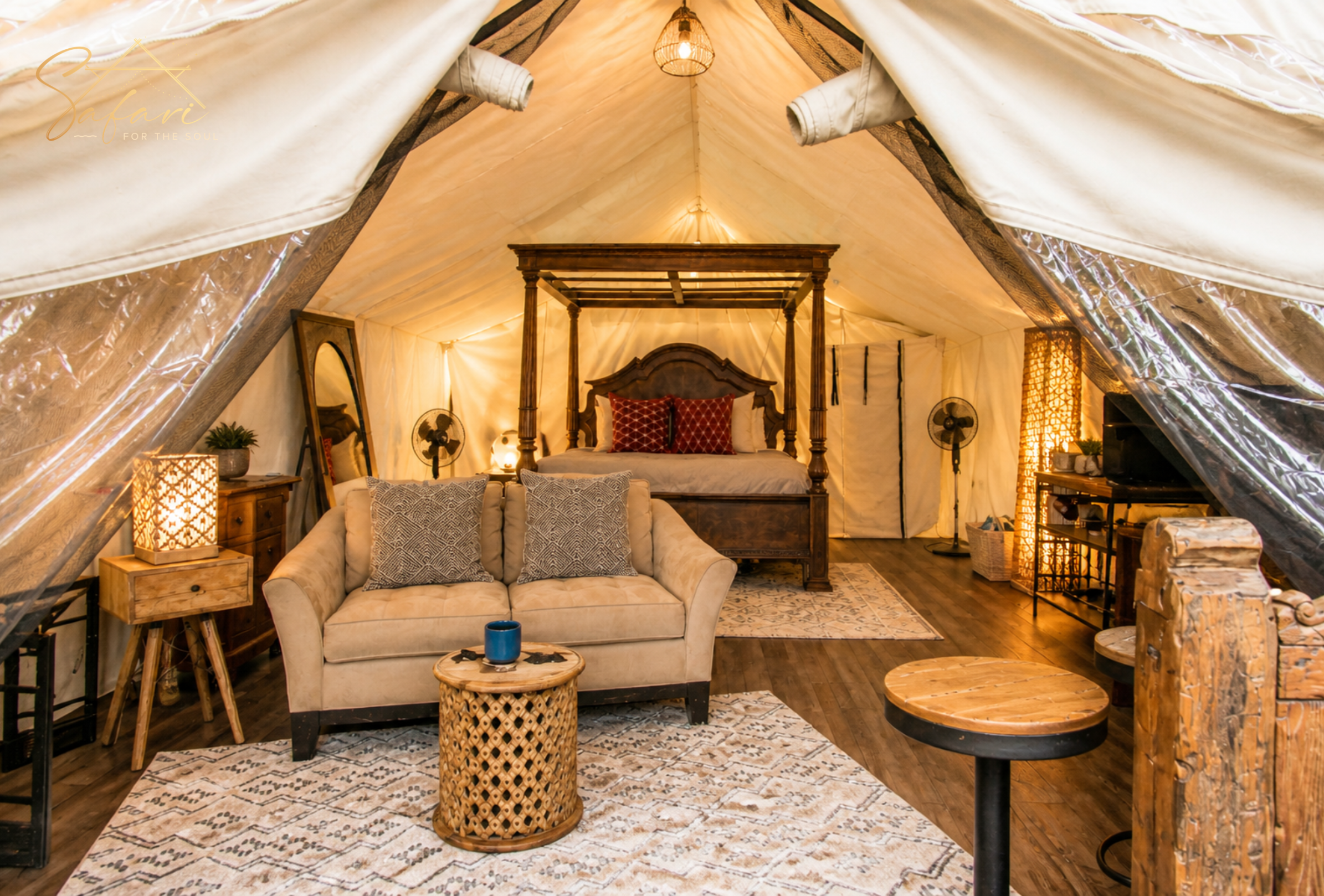 Luxury yurt interior with sofa, canopy bed, warm lighting and wooden decor