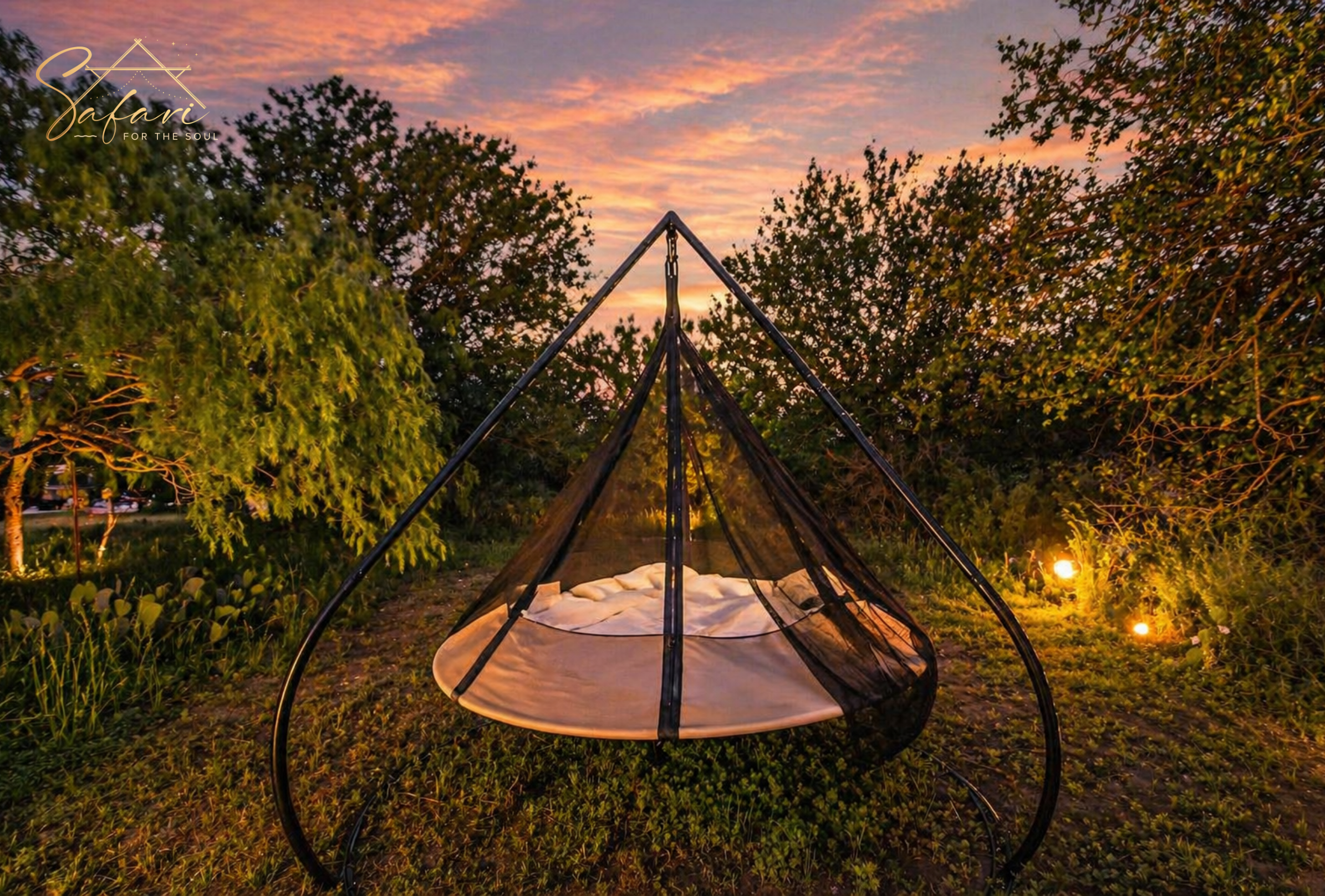 Hanging outdoor bed with net canopy surrounded by trees and sunset lighting at luxury glamping site in Marble Falls Texas