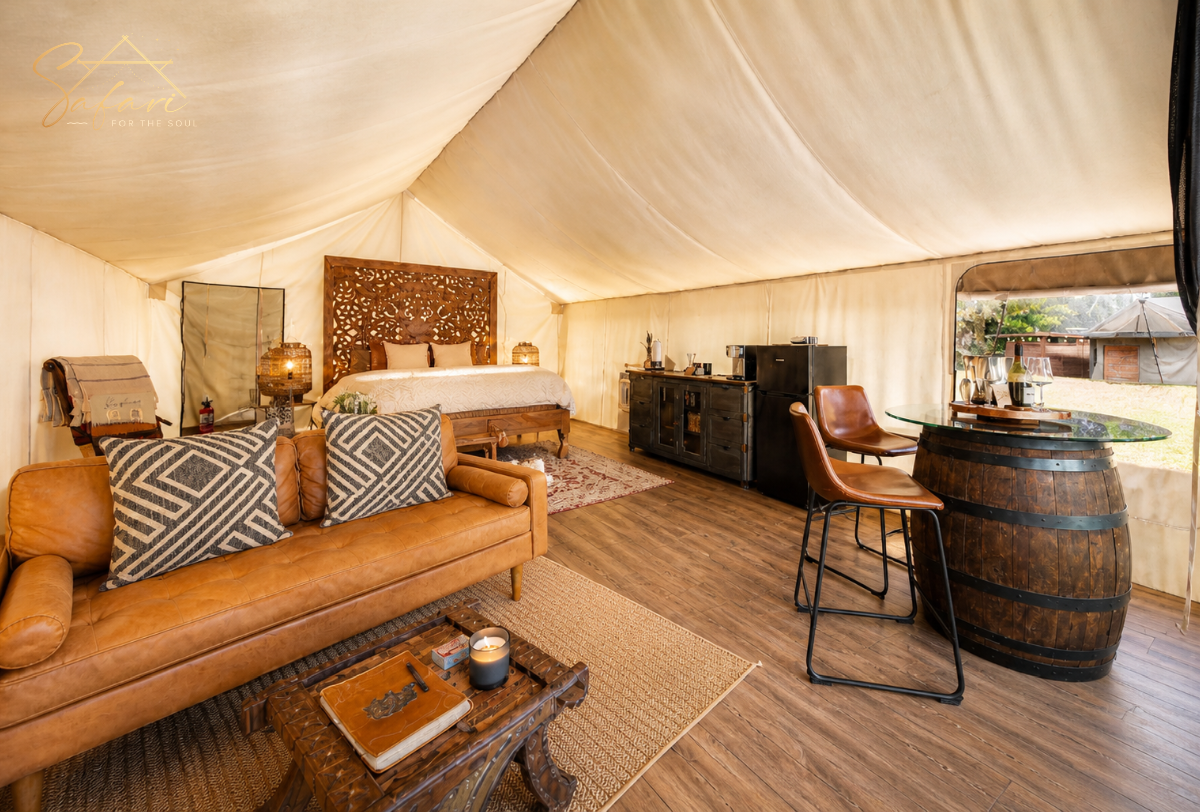 Spacious yurt interior with sofa, wooden flooring, and bar area in Marble Falls Texas glamping site